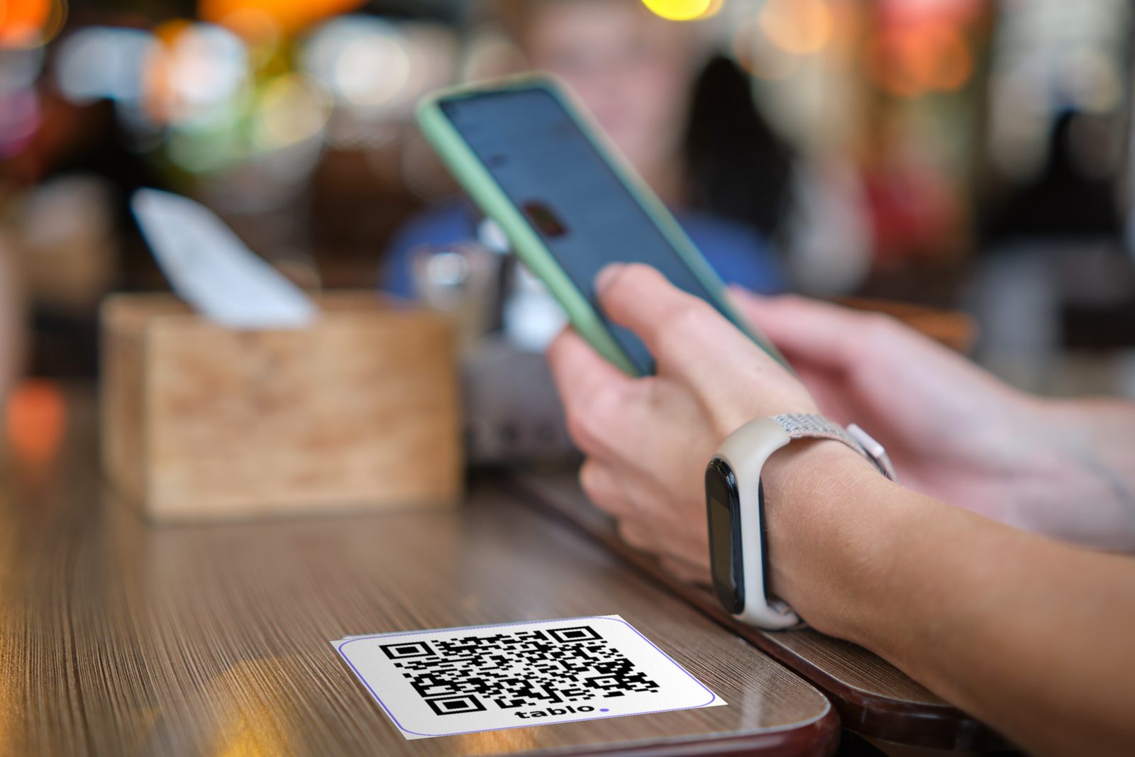 Cliente scannant le QR Tablo posé sur la table avec son téléphone